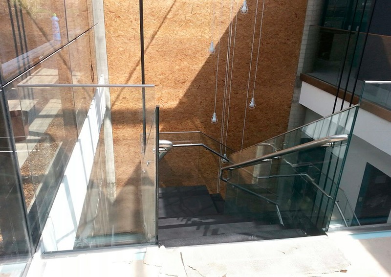 Escada com corrimão de ferro e guarda-corpo de vidro
